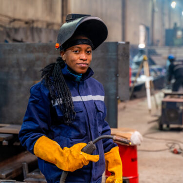A young university student female is practicing her welding skills