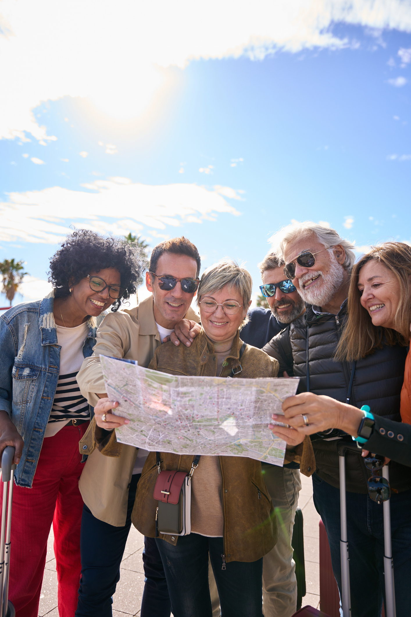 Diverse adults gather around map.