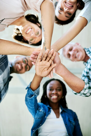 Diverse adults join hands in center of a circle