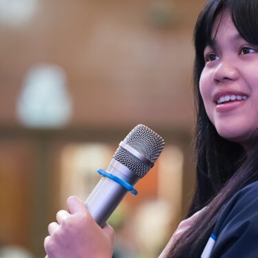Smart Businesswoman speech or Speaking with microphone in Seminar hall, hand gesturing protesting or belief for explaining in conference room. Speaker tedtalk is vocalized form of communication humans